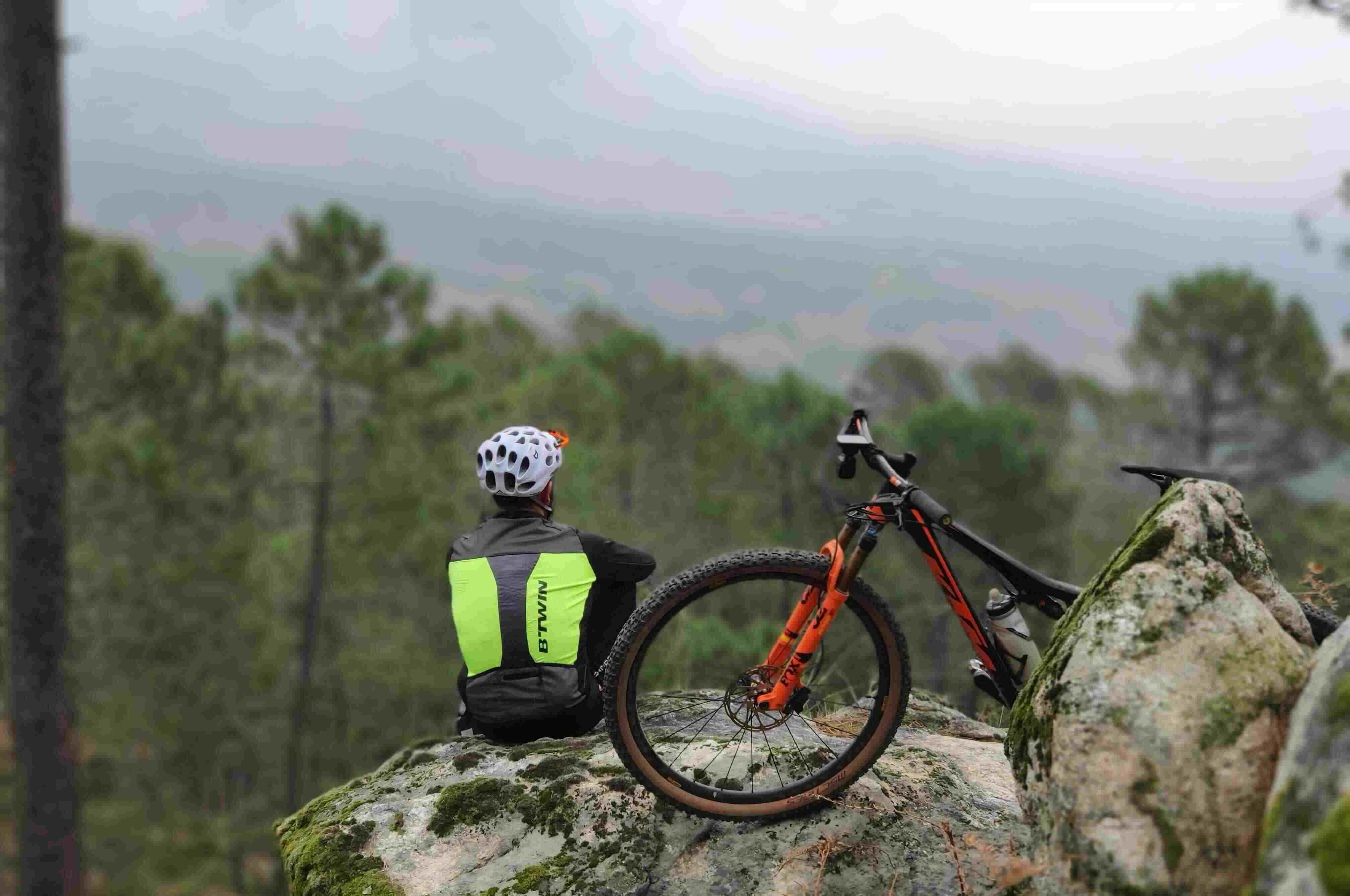 Biker sat on rocks looking into distance