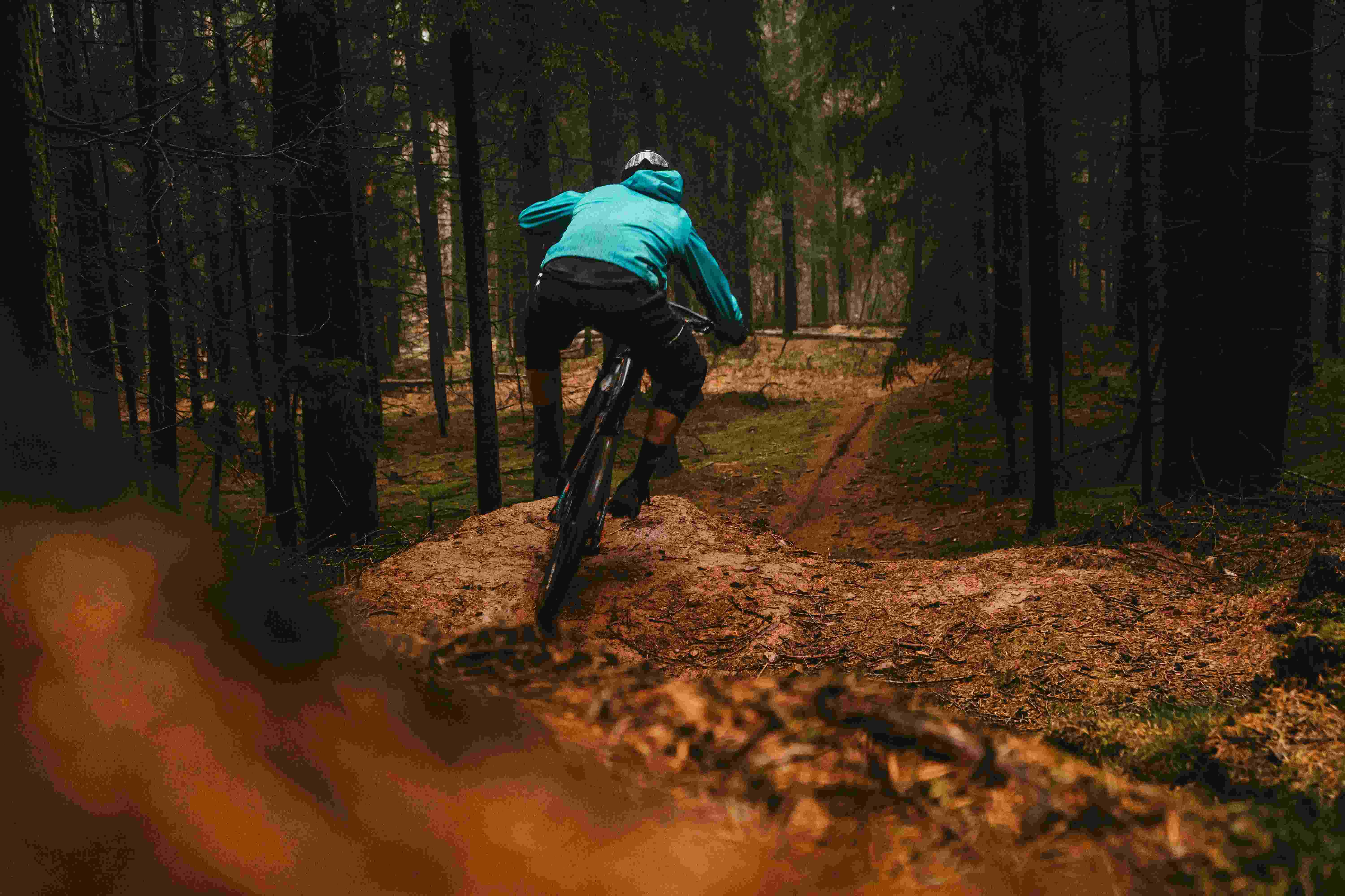 Cyclist riding through leaves on a woodland trail route